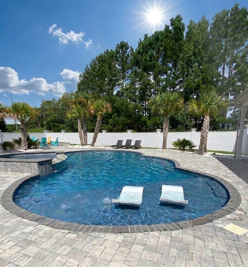 Beautiful freeform pool with palm trees and paver patio in Myrtle Beach